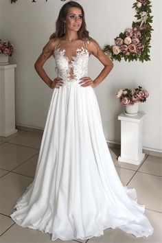 a woman standing in front of a sign wearing a wedding dress