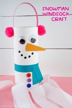 a snowman made out of toilet paper on top of a pink surface with text overlay that reads, how to make a snowman windsock craft