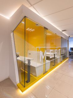 an office with glass walls and yellow accents