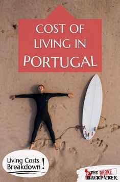 a man laying on top of a beach next to a surfboard and a sign