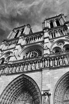 black and white photograph of the front of an old cathedral with statues on it's sides