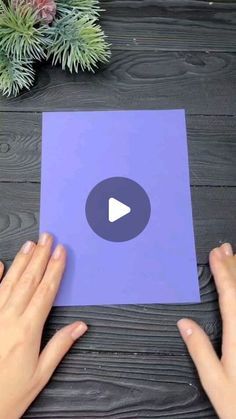 two hands holding a piece of purple paper