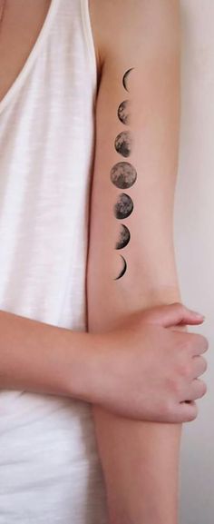 a woman's arm with phases of the moon on it