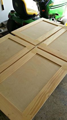 three pieces of plywood sitting on top of each other in front of a mower