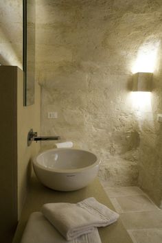 a white sink sitting under a bathroom mirror next to a wall mounted faucet