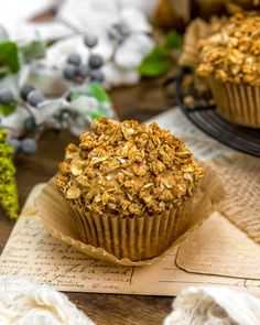 two muffins sitting on top of each other next to flowers and napkins