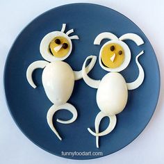 two white plastic animals made to look like eggs on a blue plate