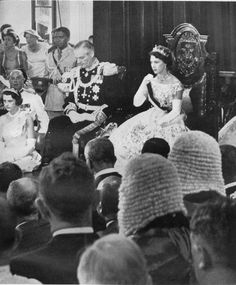 an old black and white photo of people sitting in front of a crowd