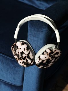 the headphones are hanging on the arm of a blue velvet chair with black and white spots