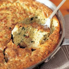 a close up of a casserole in a pan with a spoon on it