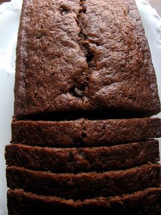 a loaf of chocolate cake sitting on top of a white plate