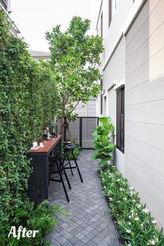 an outdoor patio with tables and chairs surrounded by greenery on either side of the building