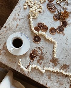 a wooden table topped with lots of food and a cup of coffee next to it