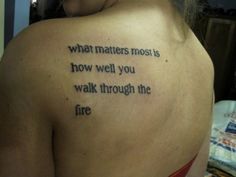 a woman with a tattoo on her back saying what matters most how well you walk through the fire