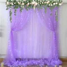 a purple wedding backdrop with flowers and candles