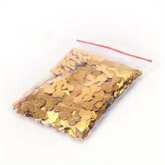 a bag filled with gold coins sitting on top of a white table next to a red string