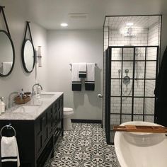 a bathroom with black and white tile flooring next to a bathtub, sink, and shower