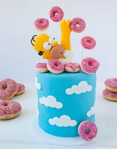 a cake with donuts and sprinkles on it that is decorated to look like the simpsons