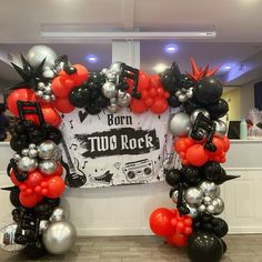 balloons are arranged in the shape of an arch for a rock band themed birthday party