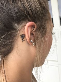 a woman with a small tattoo on her left ear