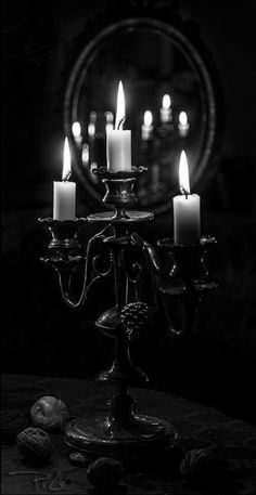 several lit candles in front of a mirror with stars on the wall behind it and a circular frame around them