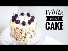 a white frosted cake with cherries on top