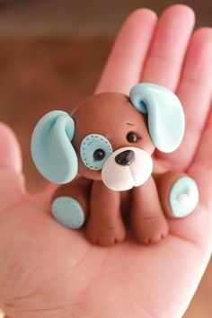 a small toy dog sitting on top of someone's hand