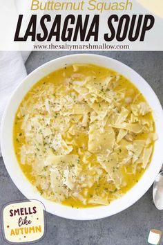 a white bowl filled with pasta and cheese on top of a gray table next to a spoon