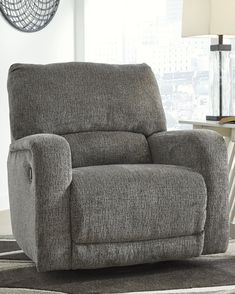 a gray recliner sitting on top of a rug