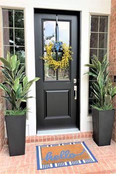 the front door is decorated with two large planters