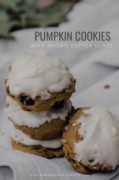 three cookies with frosting and blueberries are stacked on top of each other