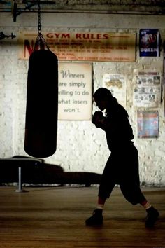 a man standing in a gym with a punching bag