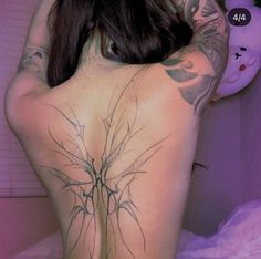 the back of a woman with tattoos on her body