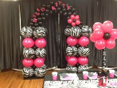 balloons and decorations are displayed on the dance floor at a birthday party in zebra print