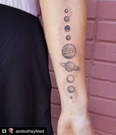 a person with a tattoo on their arm that shows the solar system and its planets