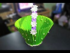 a green cup with white flowers on it and a purple straw sticking out of the top