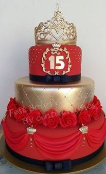 a three tiered red and gold cake with roses on the bottom is adorned with a crown