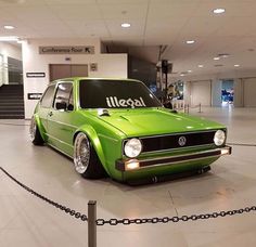 a green vw golf wagon parked in a building