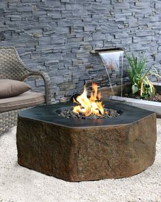 a fire pit sitting in the middle of a patio next to a couch and chair