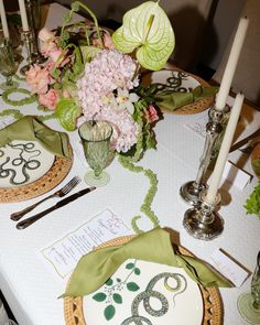 the table is set with flowers and candles