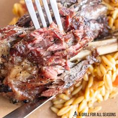 a fork sticking out of some meat on top of pasta