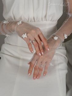 a woman in a white dress holding her hands together