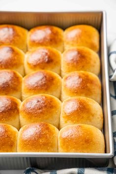 a pan filled with bread rolls on top of a blue and white towel