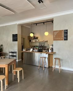 the interior of a coffee shop with tables and stools