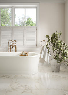 a white bath tub sitting next to a window