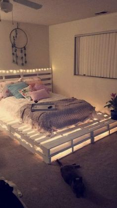 a bed that is made out of pallets and has lights on the headboard