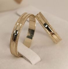 two gold rings sitting on top of each other