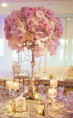 the centerpiece is adorned with pink flowers and candles for an elegant touch to the table