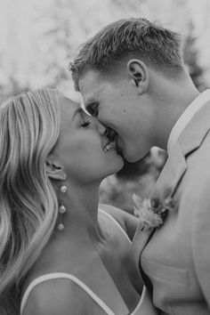 a man and woman kissing each other in black and white