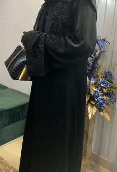 This kimono silhouette has been crafted from rich black Nida fabric with black handworked embroidery. The rich statements with stone diamonds accentuate this abaya. Style the abaya with the belt provided for a more defined look and a black pair of heels. Perfect for Eid, Ramadan or a casual evening out. Details Delivery in 14 days Open Abaya Made with premium grade black Nida fabric Hijab and belt included Pretty Black Abayas, Modesty Aesthetic, Black Open Abaya, Work Abaya, Abaya Noir, Wedding Abaya, White Abaya, Abaya Black, Prom Couples